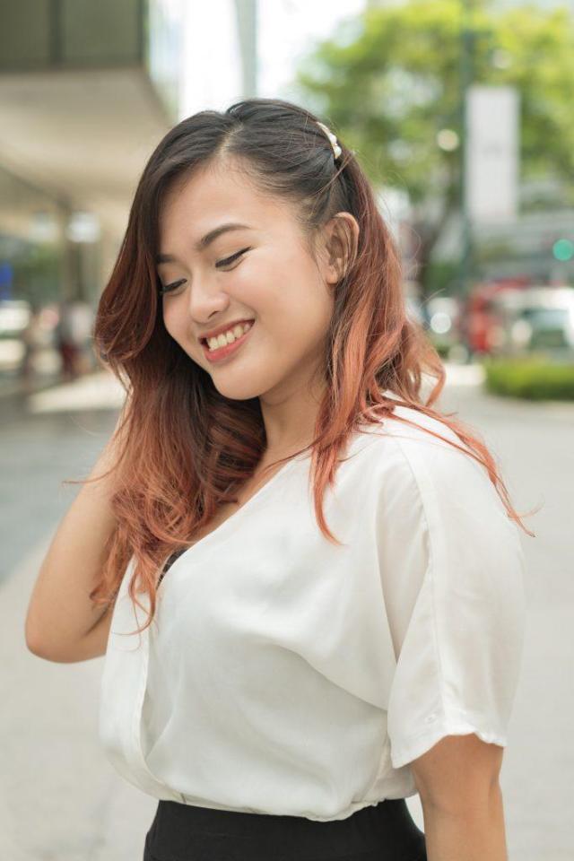 Asian woman with mahogany hair and hair clip hairstyle smiling